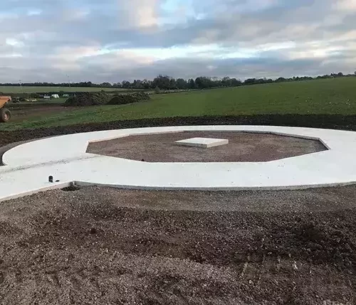 This image shows a freshly laid circular concrete base, part of specialist groundworks tailored to equestrian projects, ensuring a strong and precise foundation.