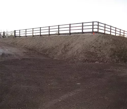 This image shows a raised equestrian arena with fencing, highlighting our site-specific drainage and grading solutions that manage water flow and ensure lasting stability.