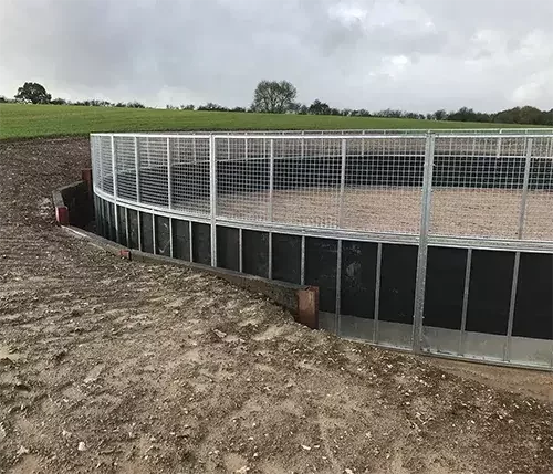 This image shows a secure round pen with durable metal mesh and kickboarding, representing our custom fencing options designed to suit your setup.