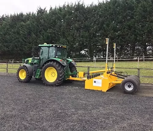 This image shows a tractor with specialist laser grading equipment, used for expert equestrian arena maintenance to ensure a level and durable riding surface.