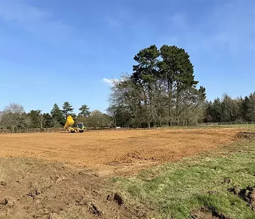 This image shows groundwork preparation on a rural site, where site surveys and consultations guide the design and construction of equestrian facilities.